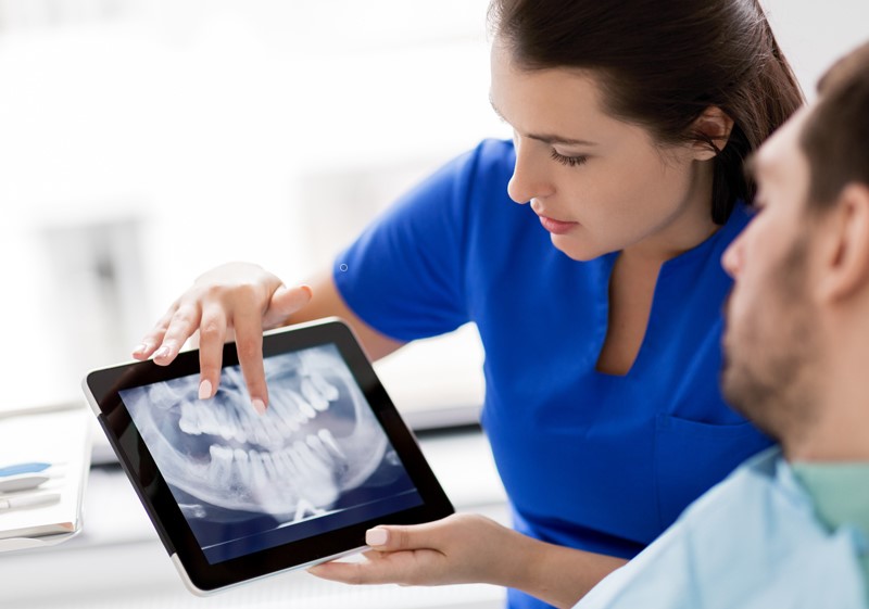 Dem Patienten wird eine Röntgenaufnahme auf dem Tablet gezeigt